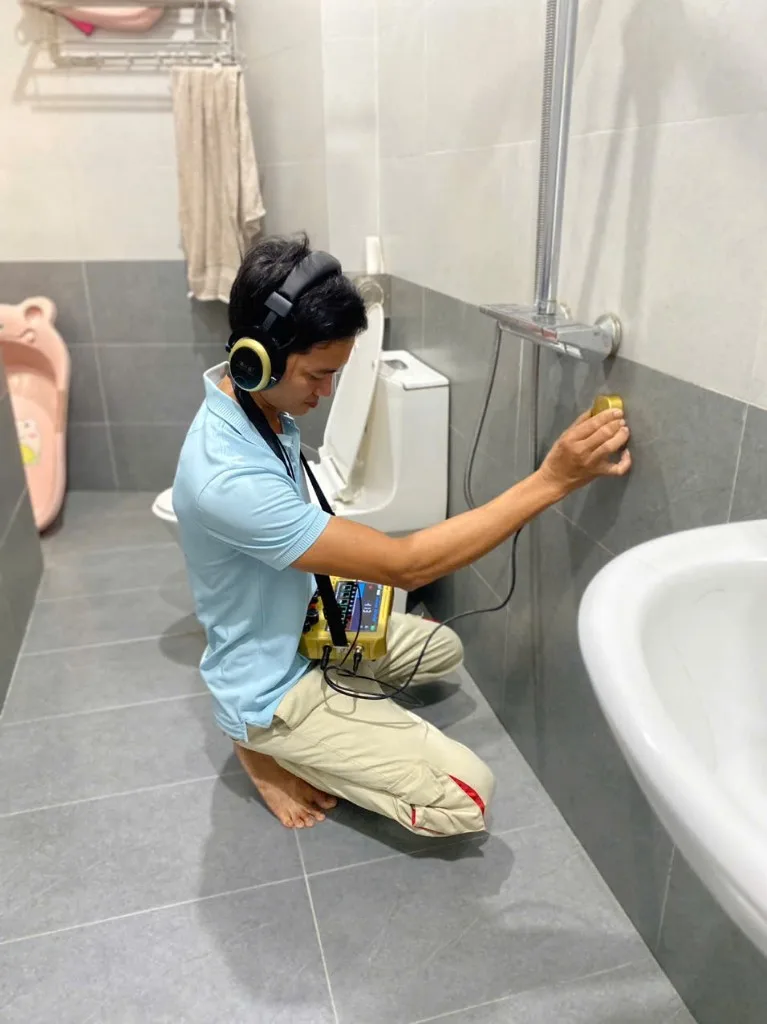Thợ Hoàng Phát dùng máy nghe dò rò rỉ nước trên tường âm tại Đà Nẵng